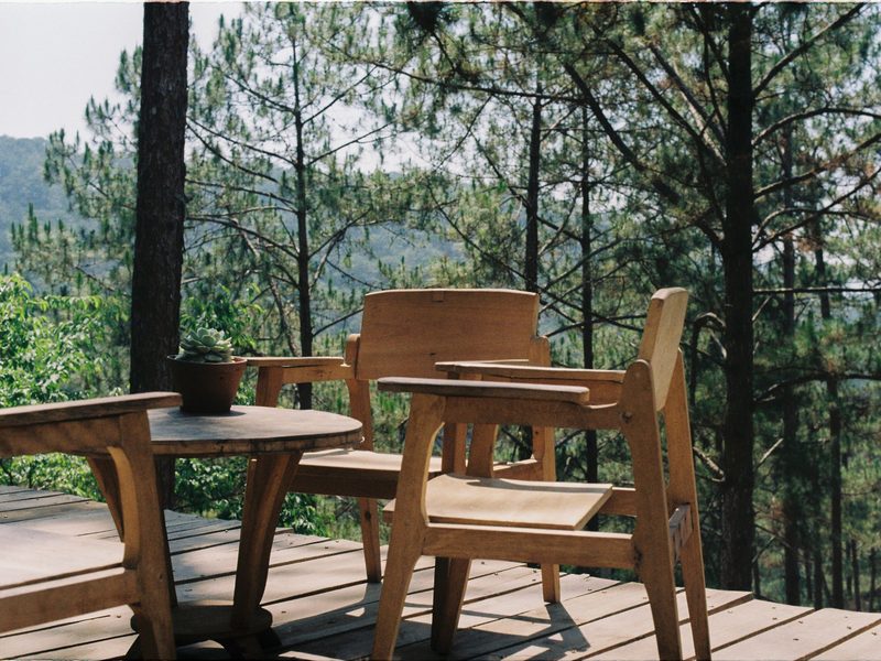 An outdoor patio with seating, surrounded by greenery